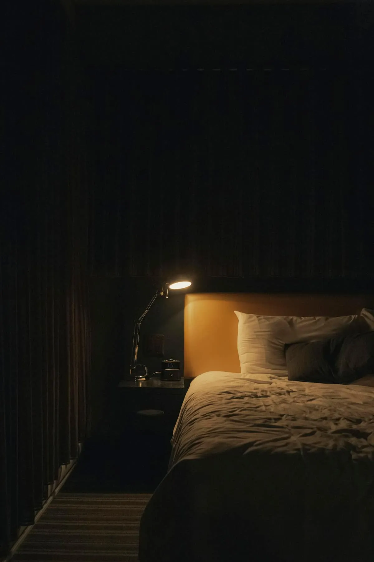 A teen at night holding a phone, face turned away